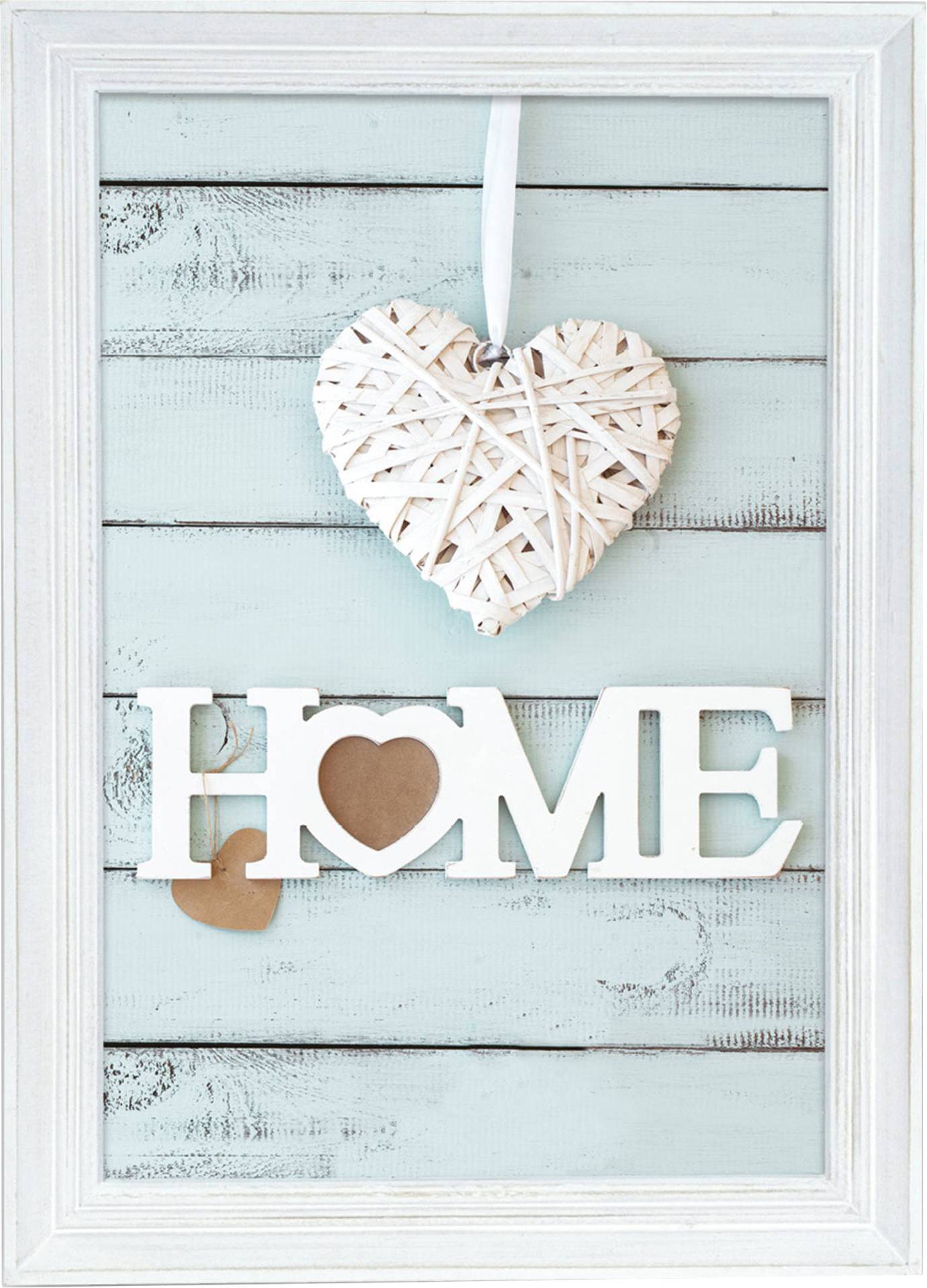 Ein gerahmtes Bild zeigt ein weißes Herz aus Rattan und das Wort 'HOME'. Der Hintergrund ist pastellblau mit Holzstruktur.