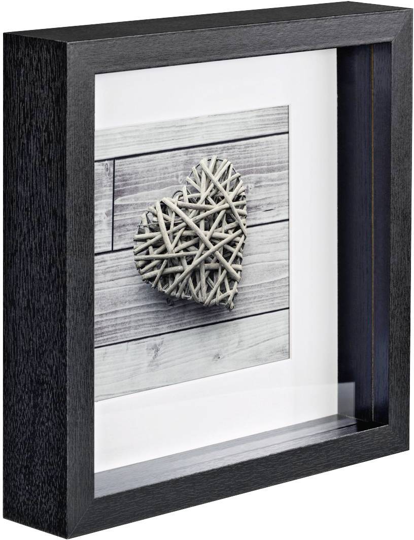 Ein gerahmtes Bild zeigt ein Herz aus verflochtenen Zweigen auf einem Hintergrund aus Holzdielen. Der Rahmen ist schwarz und tief.