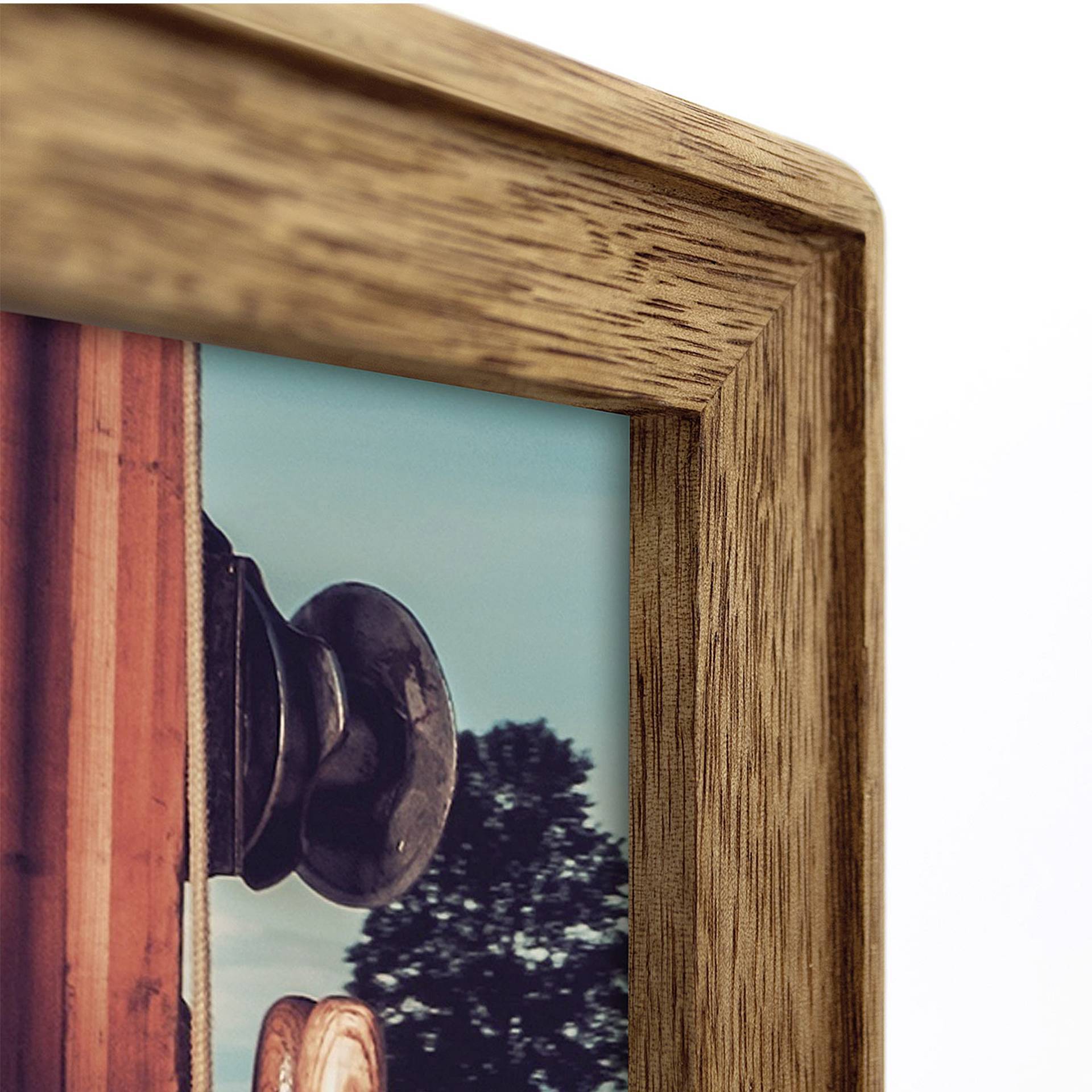 Holzrahmen mit Fotoausschnitt im Vordergrund. Auf dem Foto sind ein Türknauf und ein verschwommener Baum im Hintergrund sichtbar.