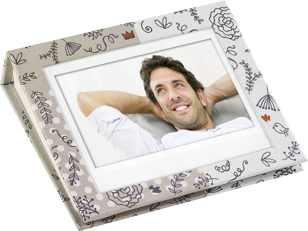 Ein lächelnder Mann lehnt sich entspannt zurück. Das Foto ist in einem dekorativen Bilderrahmen mit floralen Mustern platziert.