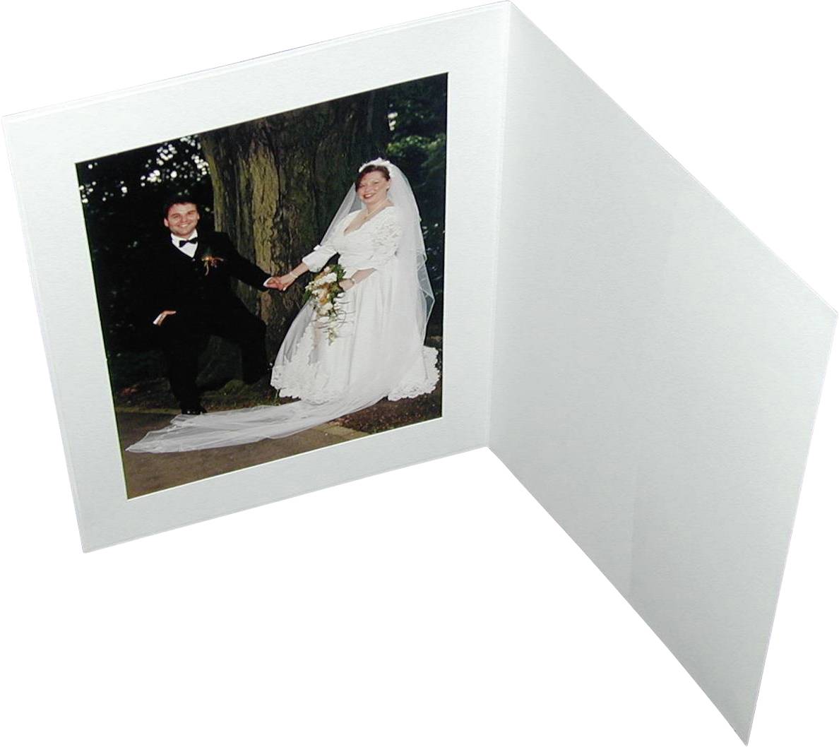 Ein Hochzeitspaar posiert lächelnd im Freien. Die Braut trägt ein weißes Kleid und Schleier, der Bräutigam einen dunklen Anzug.