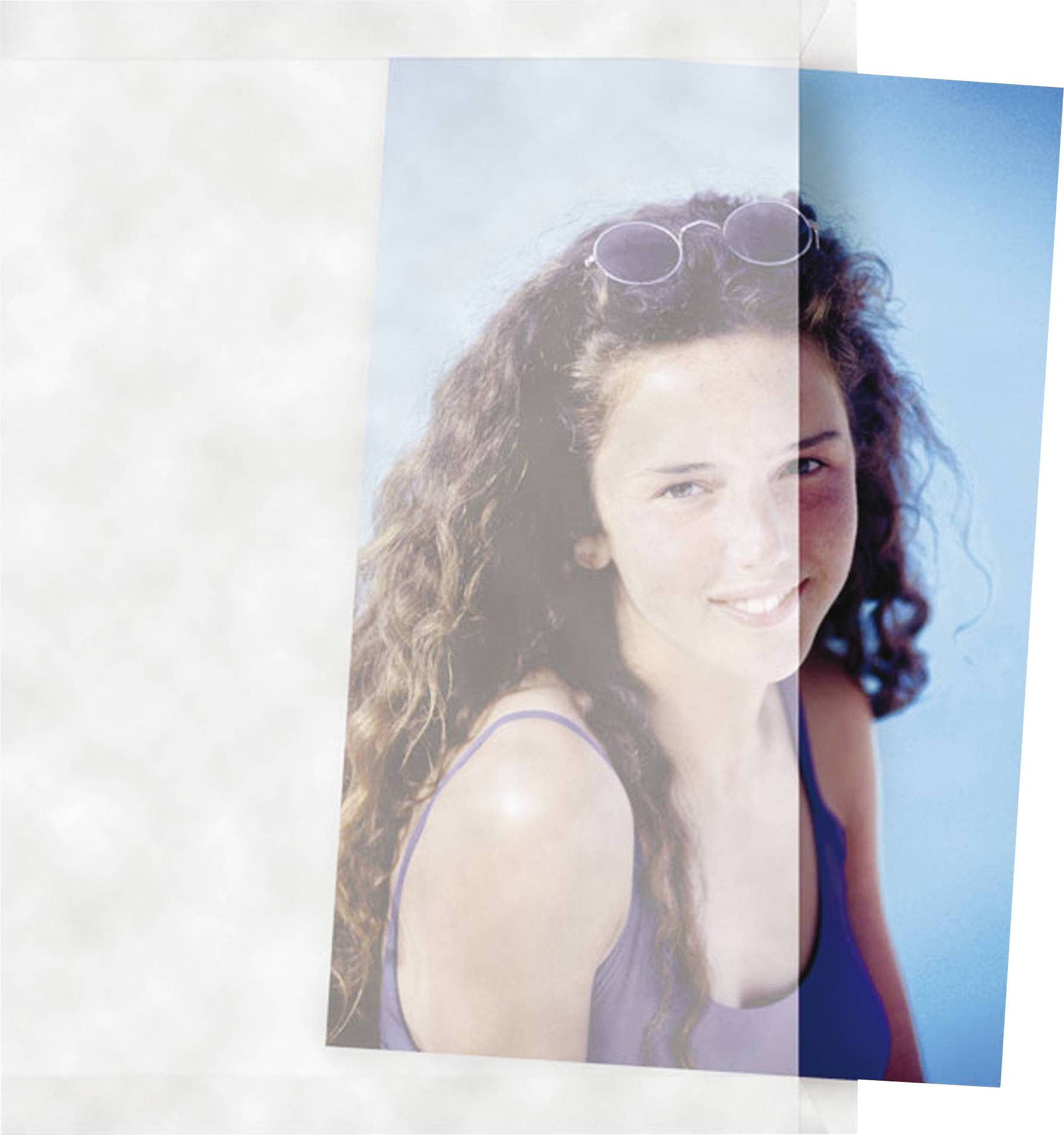 Ein lächelndes Mädchen mit lockigem Haar und Sonnenbrille auf dem Kopf vor blauem Hintergrund.