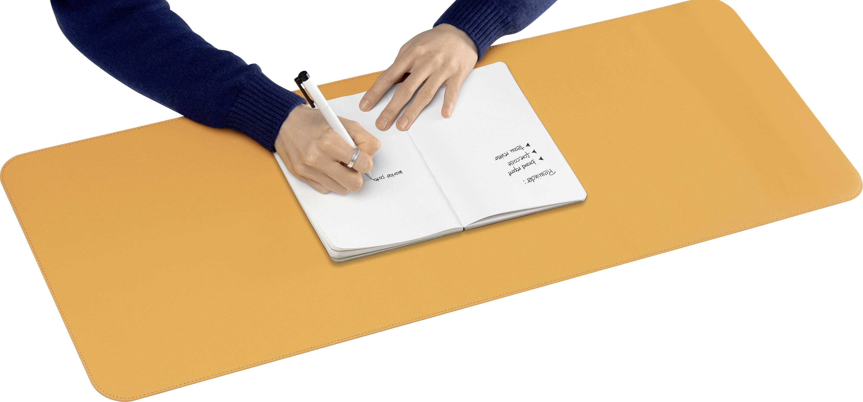 Eine Person schreibt mit einem Stift in ein Notizbuch auf einem großen, orangefarbenen Schreibtischunterlage.