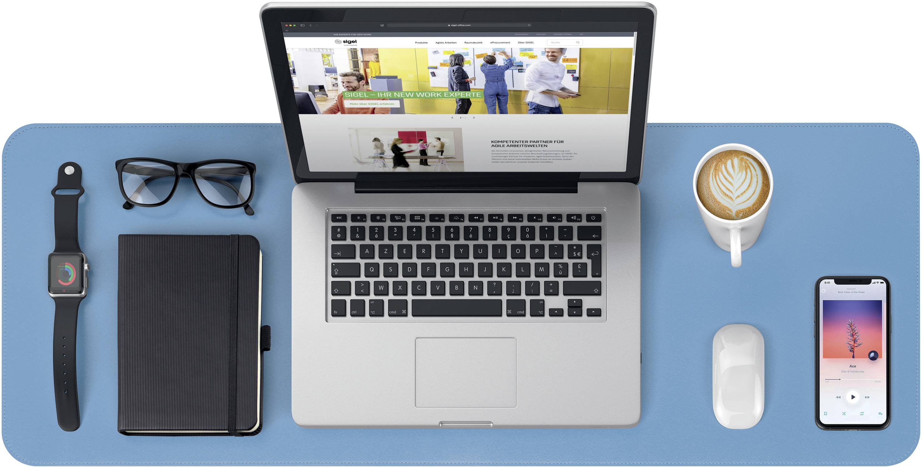 Ein aufgeräumter Schreibtisch mit Laptop, Brille, Notizbuch, Smartwatch, Kaffeeschale, Smartphone und Maus auf blauem Untergrund.