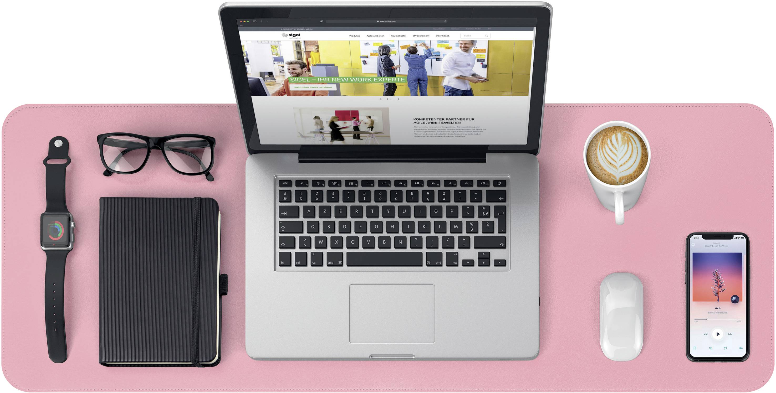 Ein Laptop auf einem rosa Schreibtisch, umgeben von einer Brille, einer Smartwatch, einem Notizbuch, einer Tasse Kaffee und einem Smartphone.