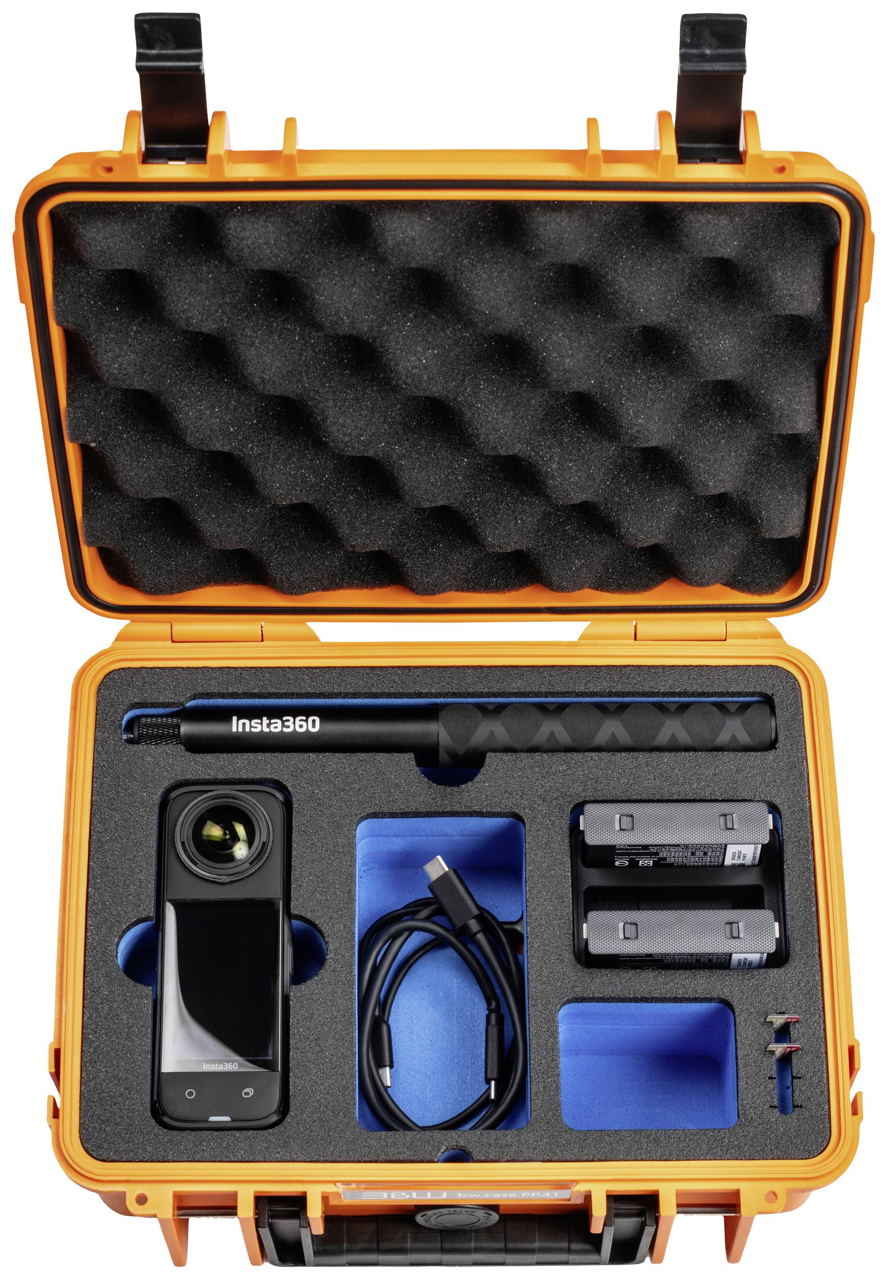 Eine offene orange Kamera-Tasche mit Schaumstoff-Einsätzen enthält eine Kamera, einen Selfie-Stick, Ladekabel und zwei Batterien.