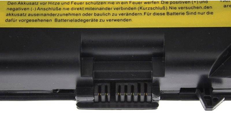 Laptop-Akku mit gelbem Warnetikett, das vor Hitze und Feuer warnt und rät, die Anschlüsse nicht zu verbinden oder zu verändern.