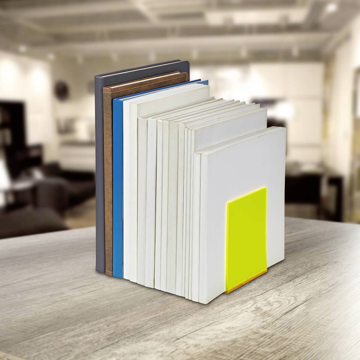 Eine Reihe von Büchern steht vertikal auf einem Tisch in einem hellen Raum. Eines der Bücher hat ein auffälliges gelbes Cover.