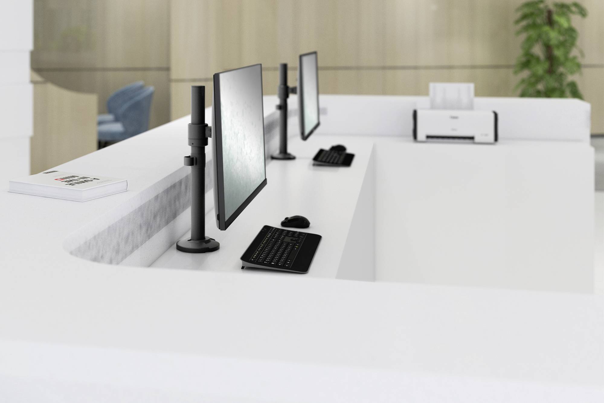 Empfangstheke mit zwei Computern, Tastaturen und Monitoren in einem modernen Büro. Im Hintergrund eine Pflanze und ein Drucker.