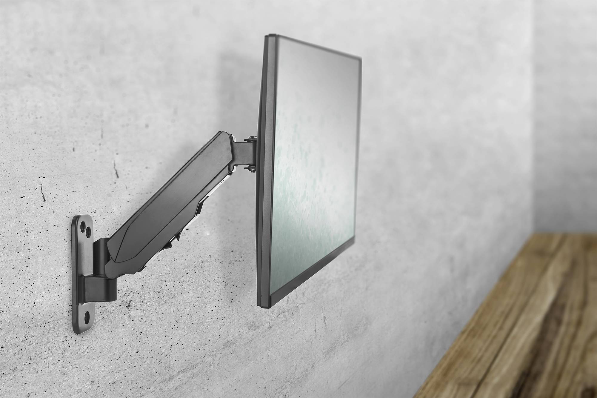 Ein Flachbildschirm ist an einer grauen Wand montiert. Der Bildschirm ist nach links geneigt, neben einer Holzoberfläche.