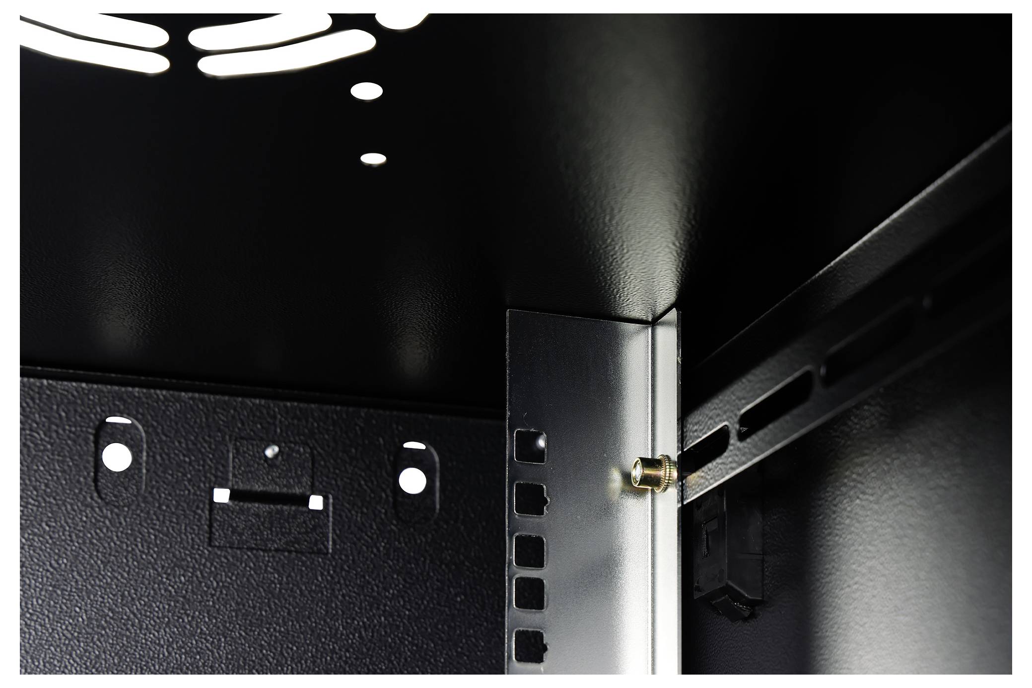 Das Bild zeigt die Innenecke eines Metallschranks und hebt die strukturelle Verstärkung mit Nieten und gelochten Belüftungspaneelen hervor.