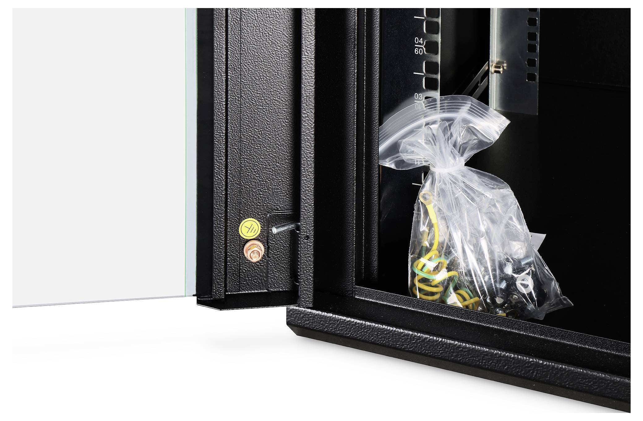 Ein Tresor ist geöffnet und zeigt einen Plastikbeutel mit Kabeln. Die Tür ist mit kleinen Warnaufklebern versehen.