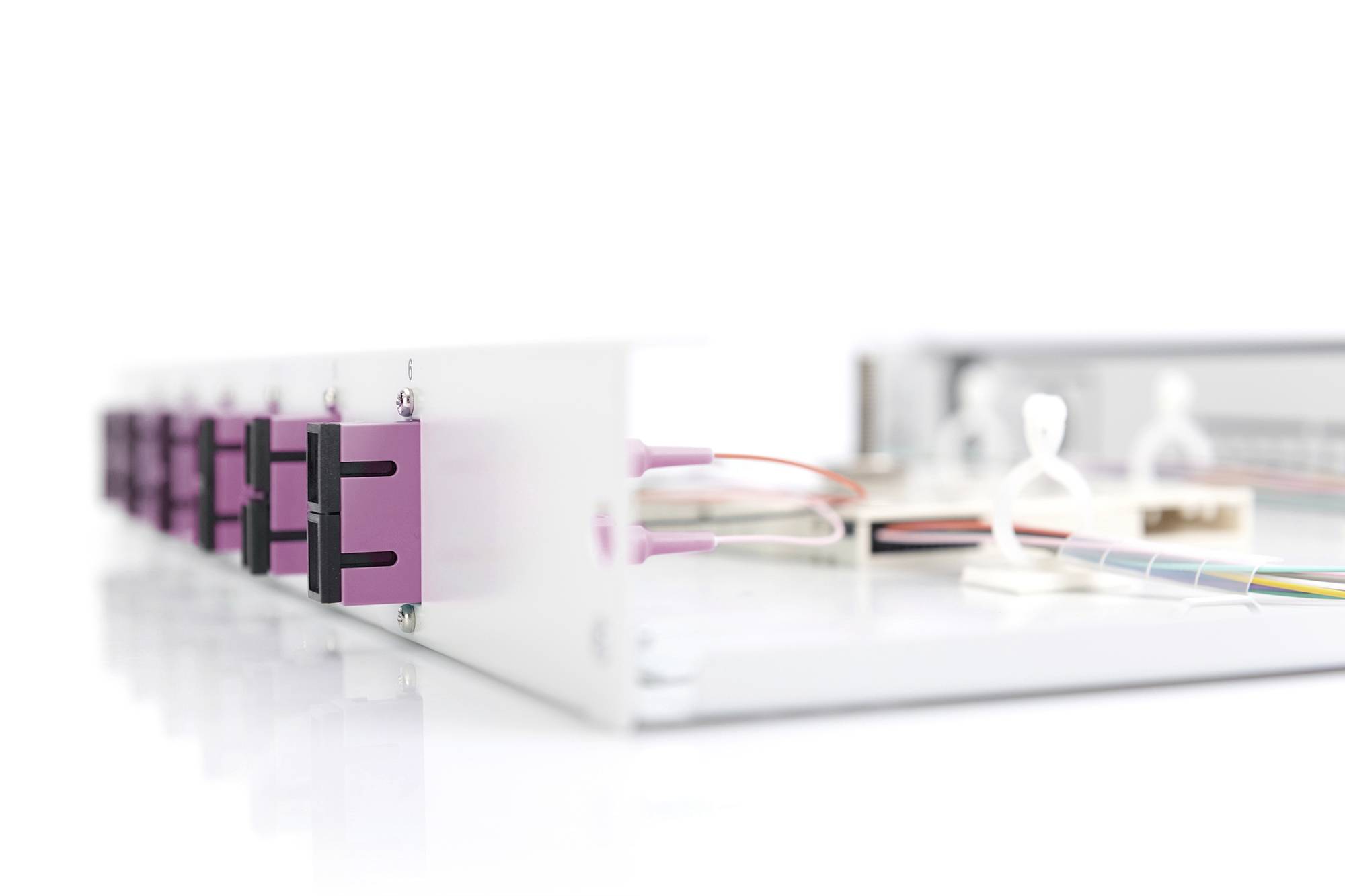 Weiße Bank mit mehreren rosa Ethernet-Ports und farbigen Kabeln.