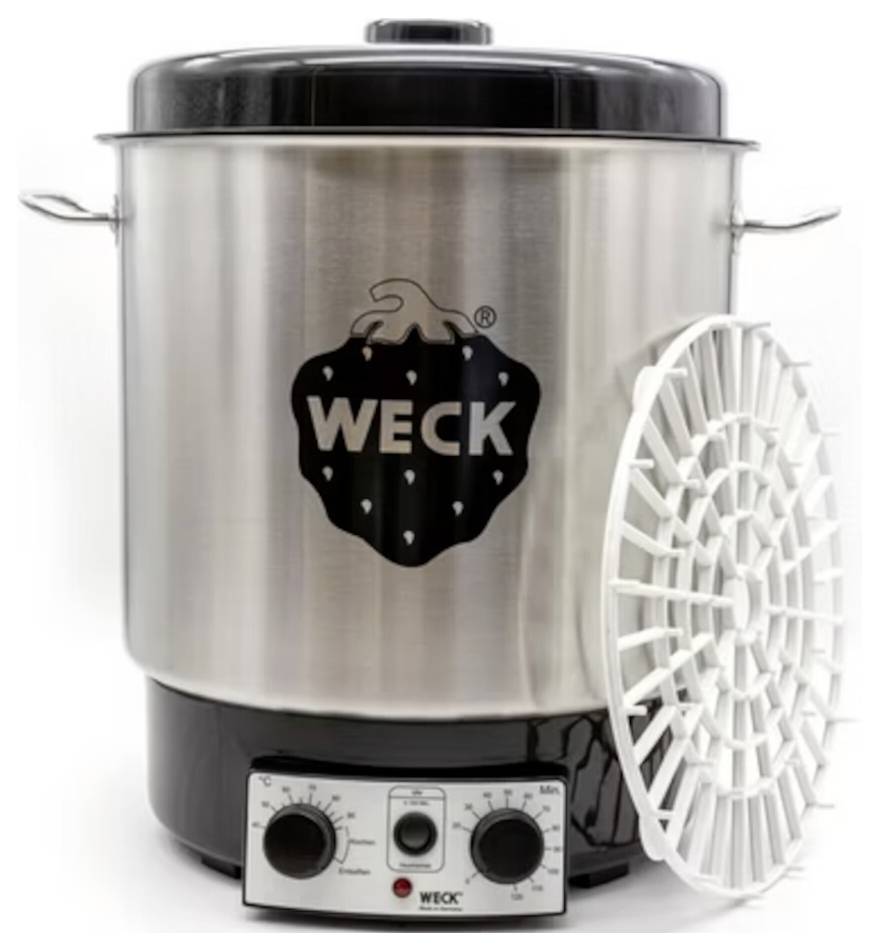 Einmachtopf der Marke 'WECK' aus Edelstahl mit Griffen, einem schwarzen Deckel und einem Temperaturregelknopf an der Basis; ein weißer Kunststoffkorb ist daneben gestellt.
