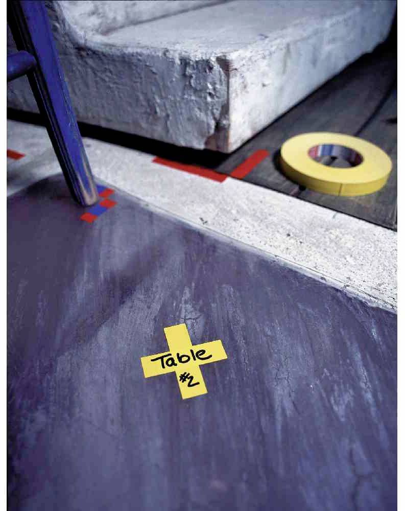 Ein gelbes Klebeband auf dem Boden mit der Aufschrift 'Table #2' verweist auf eine Markierung vor einer Treppenstufe. Ein weiteres gelbes Band liegt daneben.