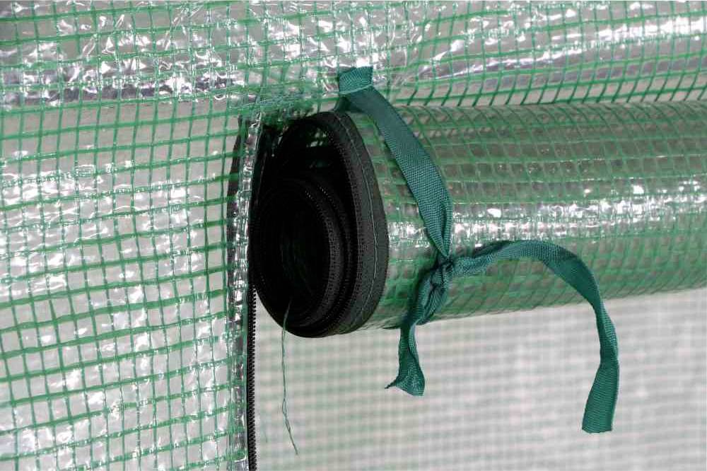 Grüne, gerollte Kunststoffplane mit Gittermuster und befestigtem Band, vermutlich Teil eines Gewächshauses oder Schutzzeltes.