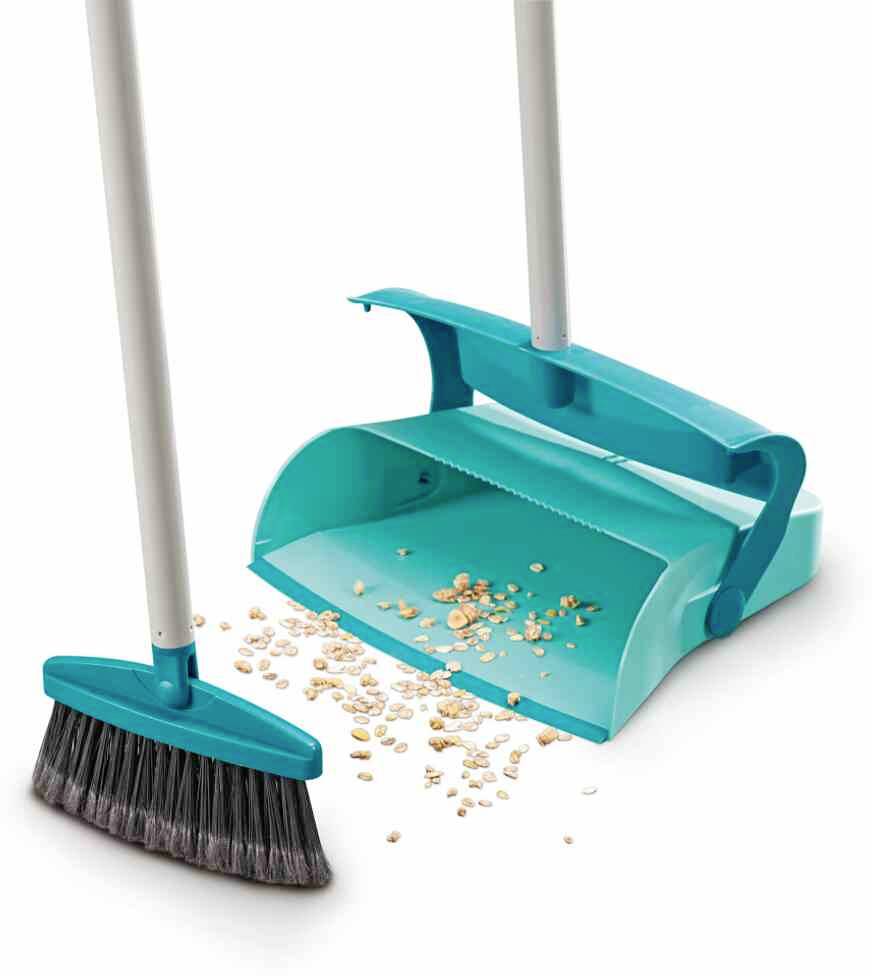 Blauer Besen und Kehrschaufel-Set mit heruntergefallenen Cornflakes auf dem Boden, bereit zum Aufräumen.