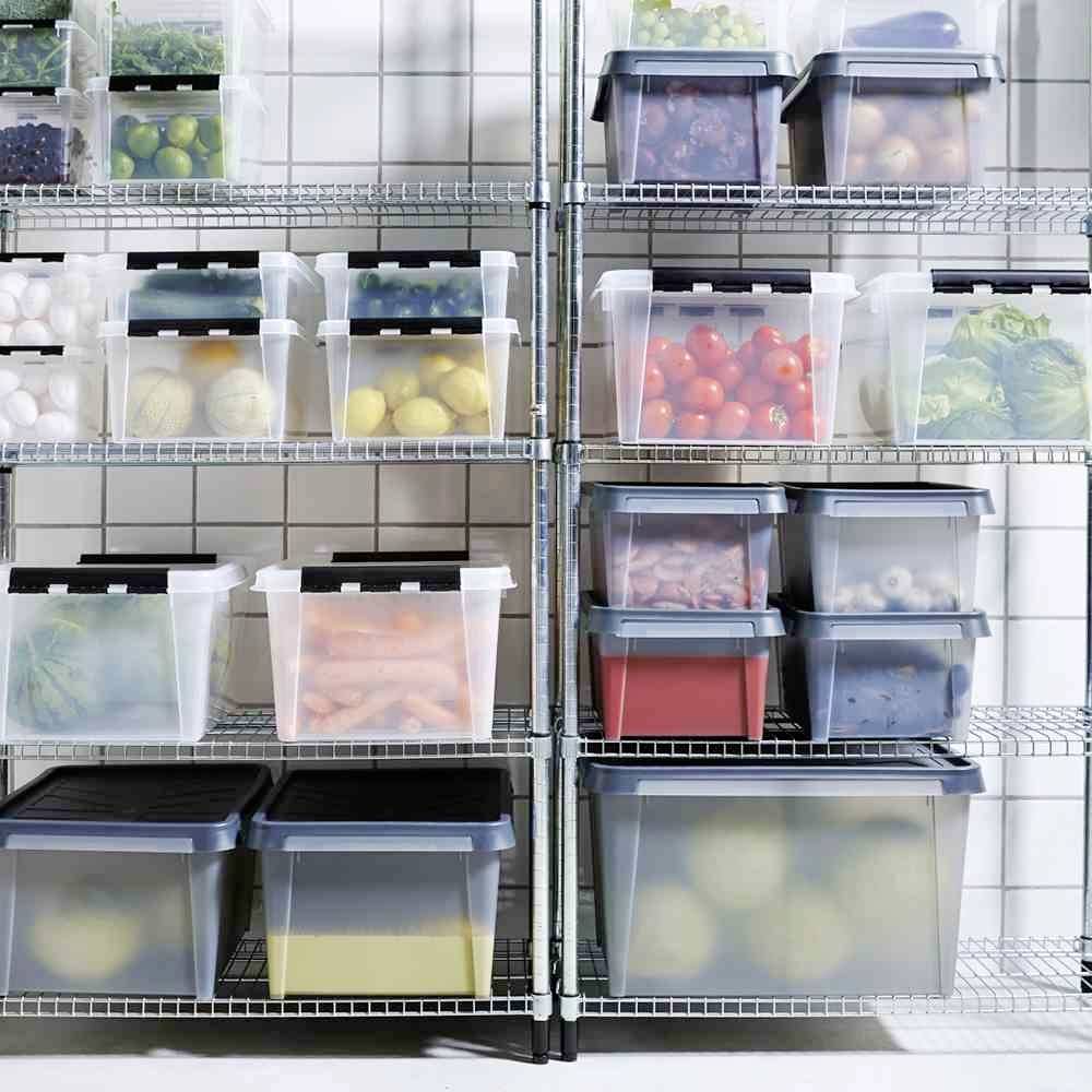 Mehrere Regale mit transparenten Plastikboxen voller verschiedener Lebensmittel, darunter Gemüse, Obst und Eier, in einer Vorratskammer.