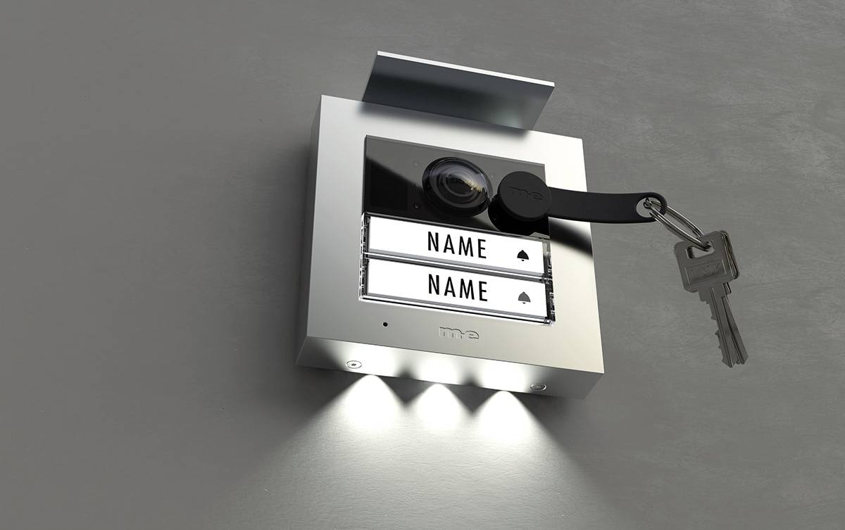 Türsprechanlage mit zwei Namensschildern 'Name'. Schlüssel am Band oben rechts eingesteckt. Beleuchtet von unten.