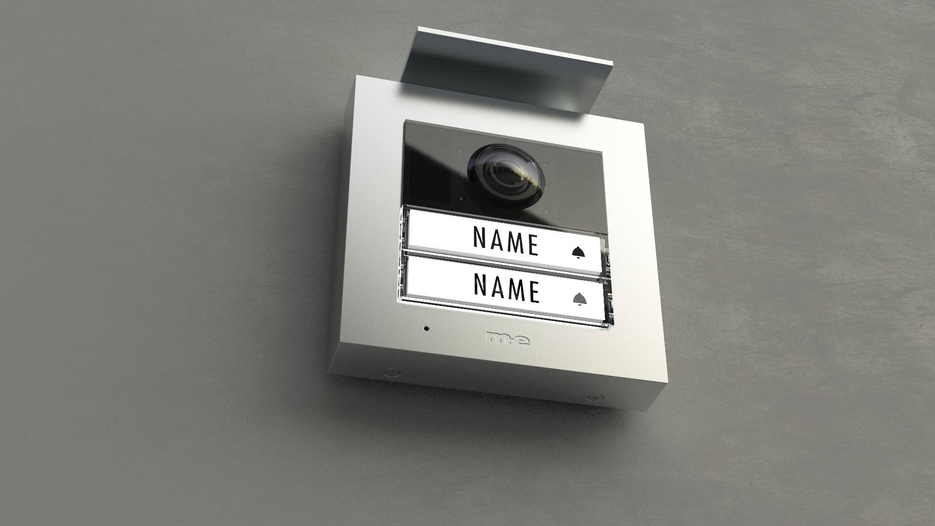Klingelschild an einer modernen Gebäudefassade mit zwei leeren Namensfeldern unter einer Kamera.