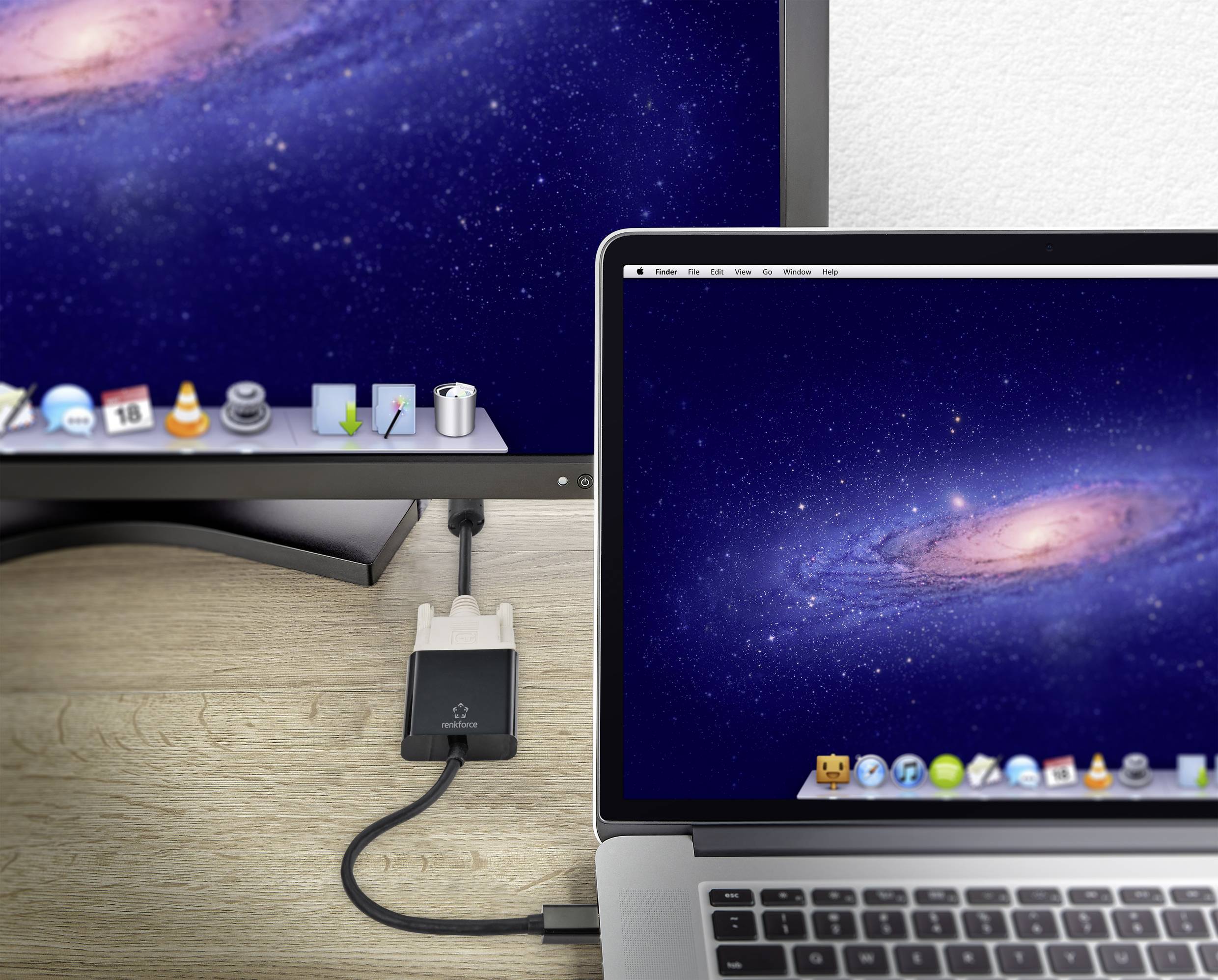 Ein Laptop und ein Monitor zeigen identische Weltraum-Hintergrundbilder. Der Laptop ist mit dem Monitor über ein einzelnes Kabel verbunden.