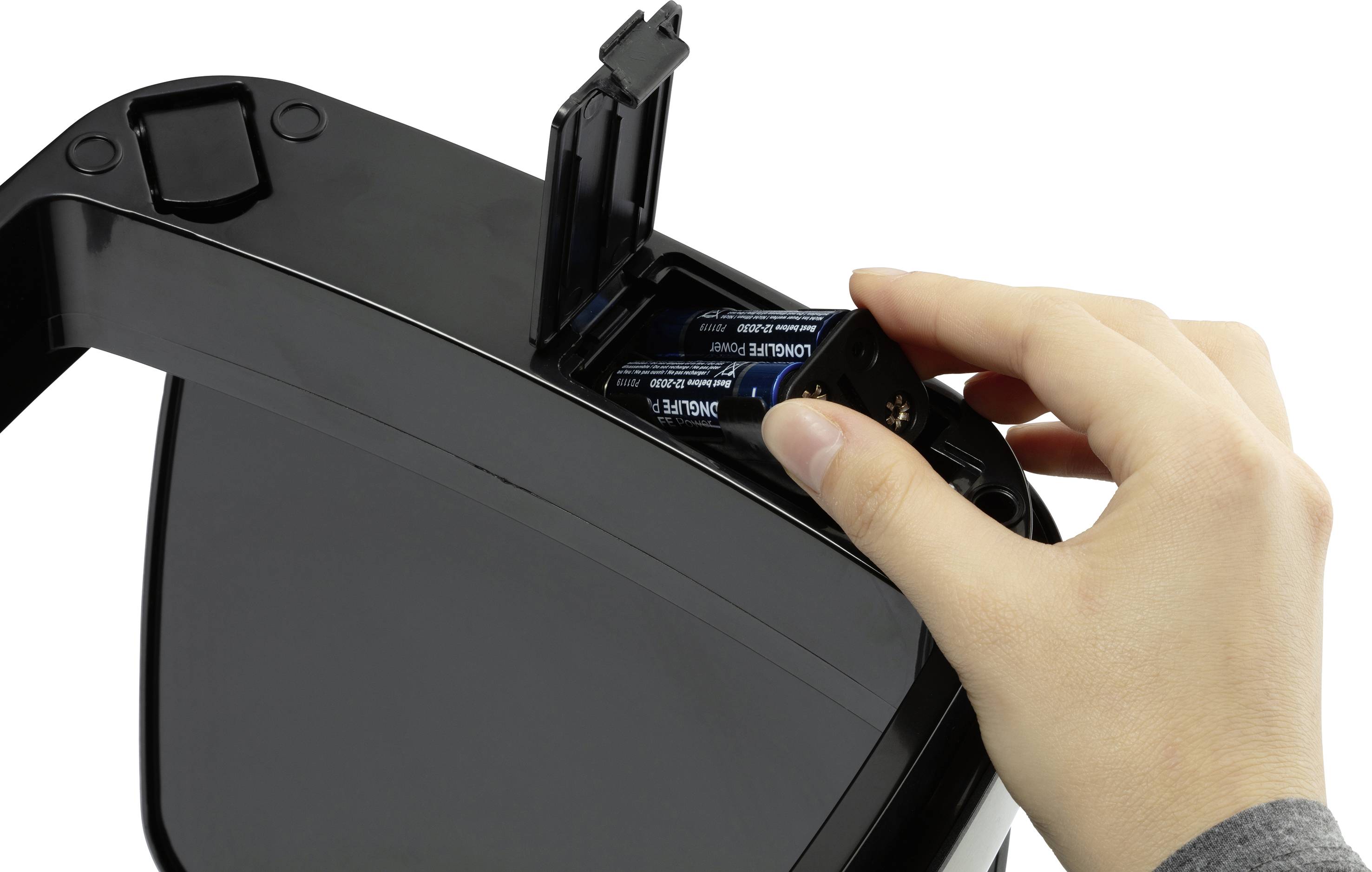 Eine Person setzt Batterien in ein elektronisches Gerät mit einem Batteriefach ein.