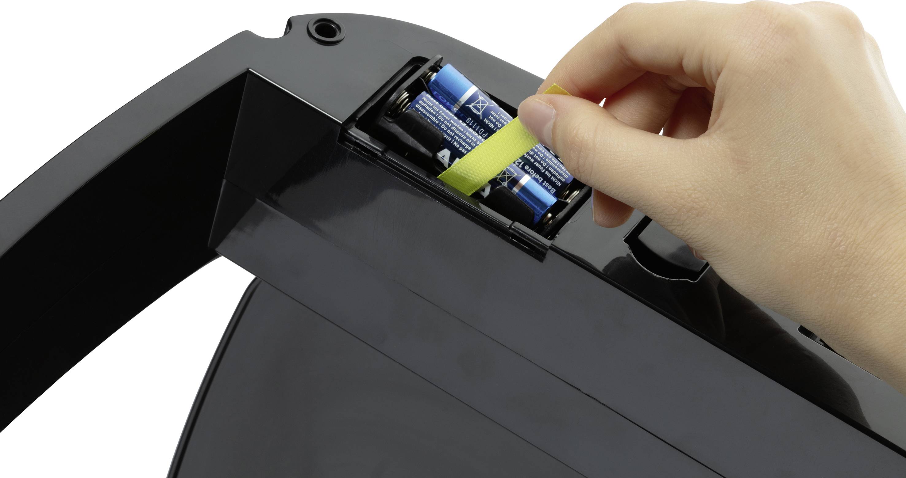 Hand legt Batterien in ein schwarzes Gerät ein. Eine gelbe Lasche erleichtert das Einlegen und Herausnehmen der Batterien.