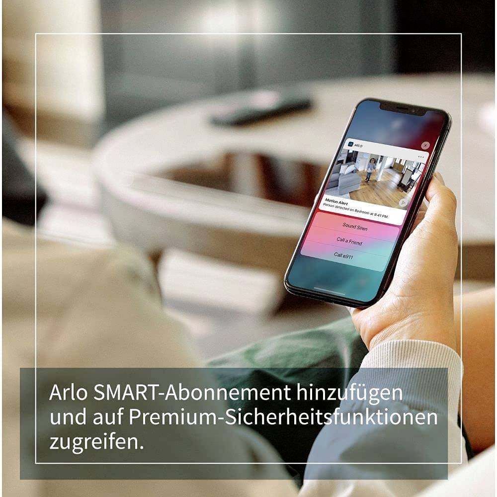 Person hält Smartphone mit Arlo SMART Abonnement-Bildschirm. Textfeld: 'Arlo SMART-Abonnement hinzufügen und auf Premium-Sicherheitsfunktionen zugreifen.'