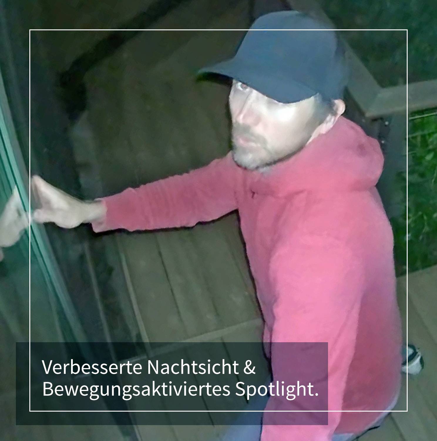 Ein Mann in rotem Hoodie und dunkler Mütze schaut nach oben. Unten im Bild steht: 'Verbesserte Nachtsicht & Bewegungsaktiviertes Spotlight.'