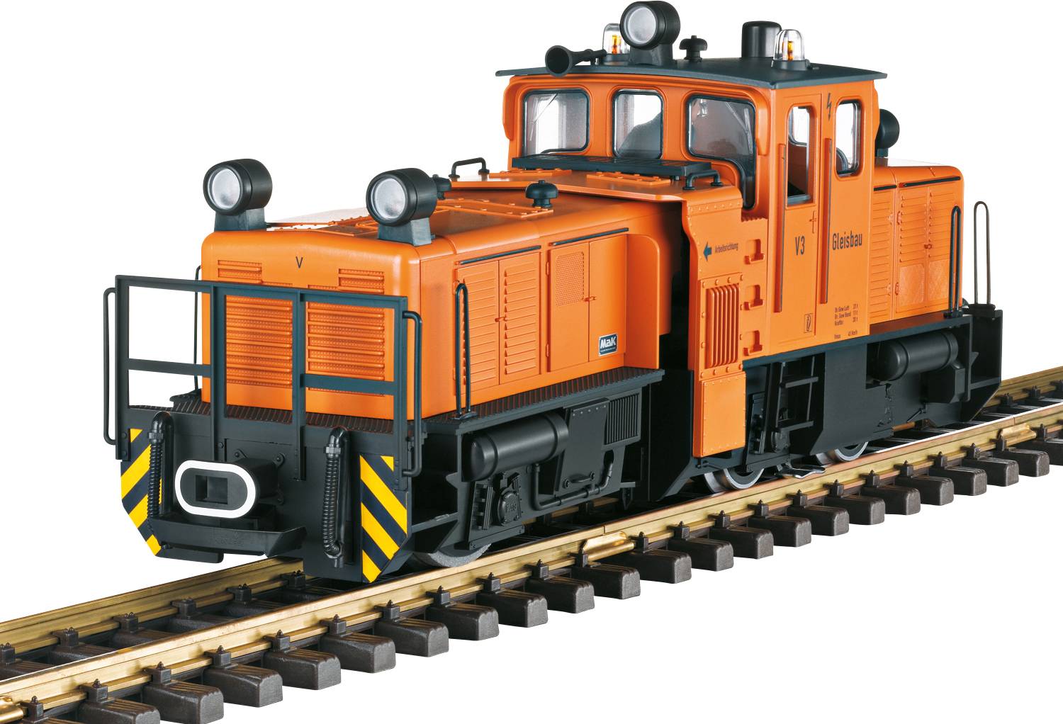 Eine orangefarbene Lokomotive auf Eisenbahnschienen. Sie hat vier Scheinwerfer, schwarze Sicherheitsstreifen und ist für den Rangierbetrieb ausgelegt.