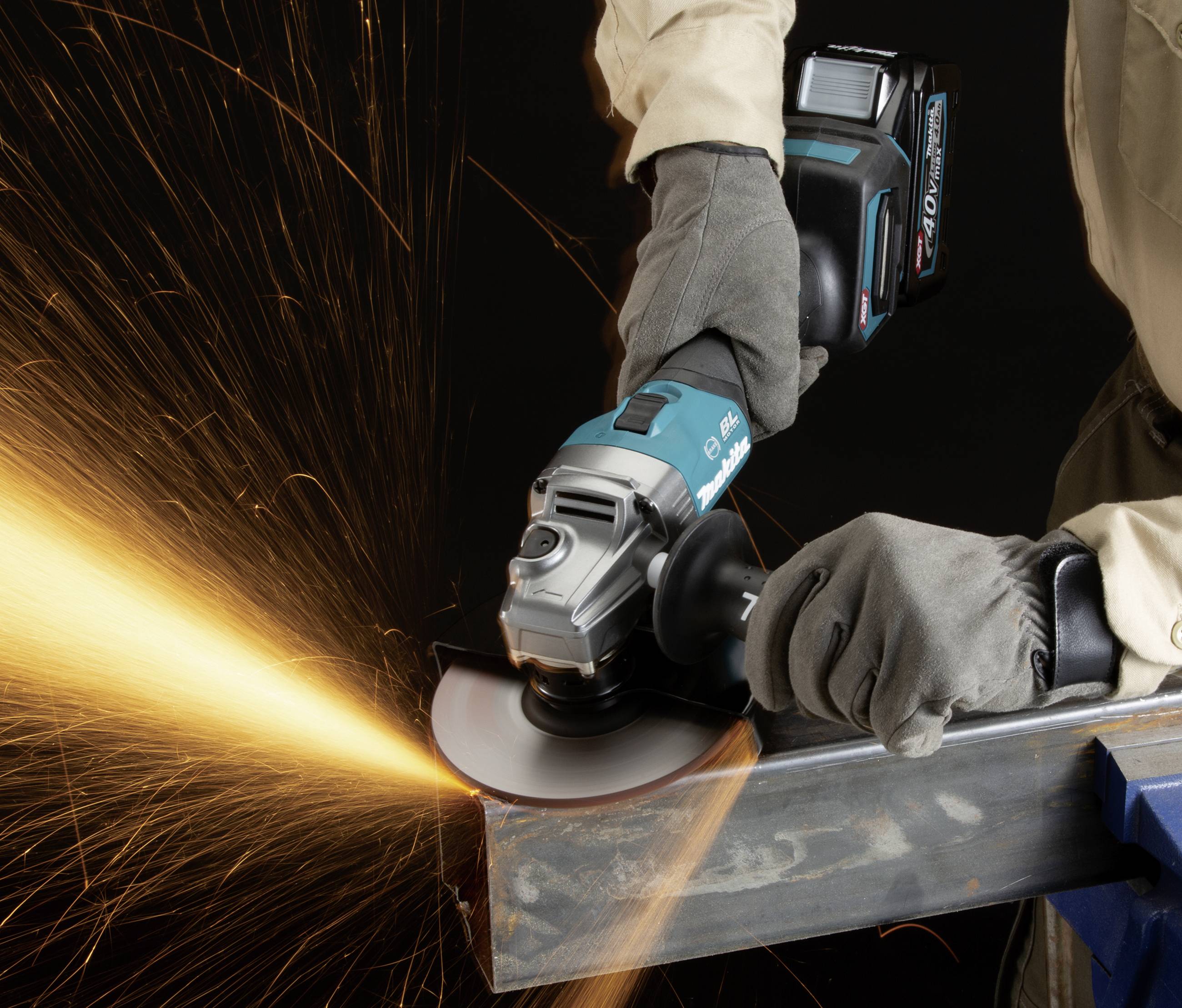 Werkzeug in Aktion: Ein Arbeiter trägt Sicherheitshandschuhe und schneidet mit einem Winkelschleifer Metall, Funken fliegen.