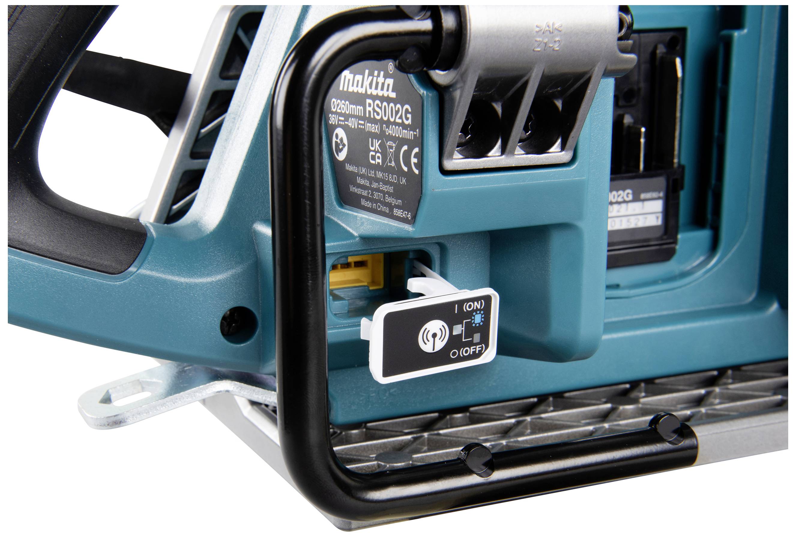 Ein Nahaufnahme eines blauen Elektrowerkzeug-Bedienfelds mit einem Ein/Aus-Schalter und technischen Details im Hintergrund.