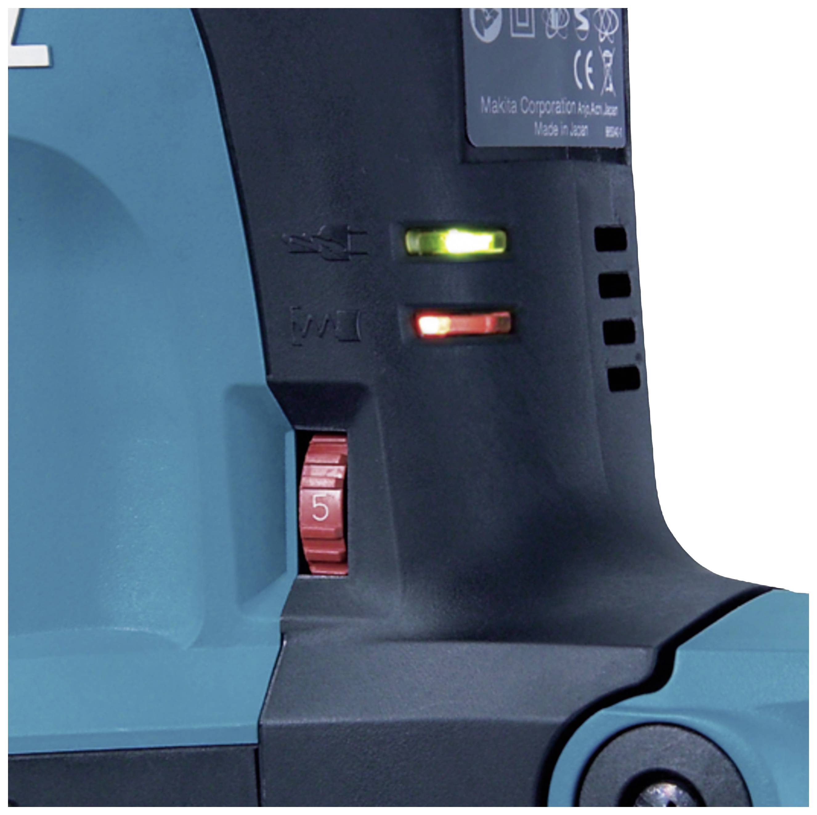 Ein Detail einer elektrischen Maschine mit zwei leuchtenden Kontrollleuchten, einer roten und einer grünen, sowie einem roten Einstellrad.