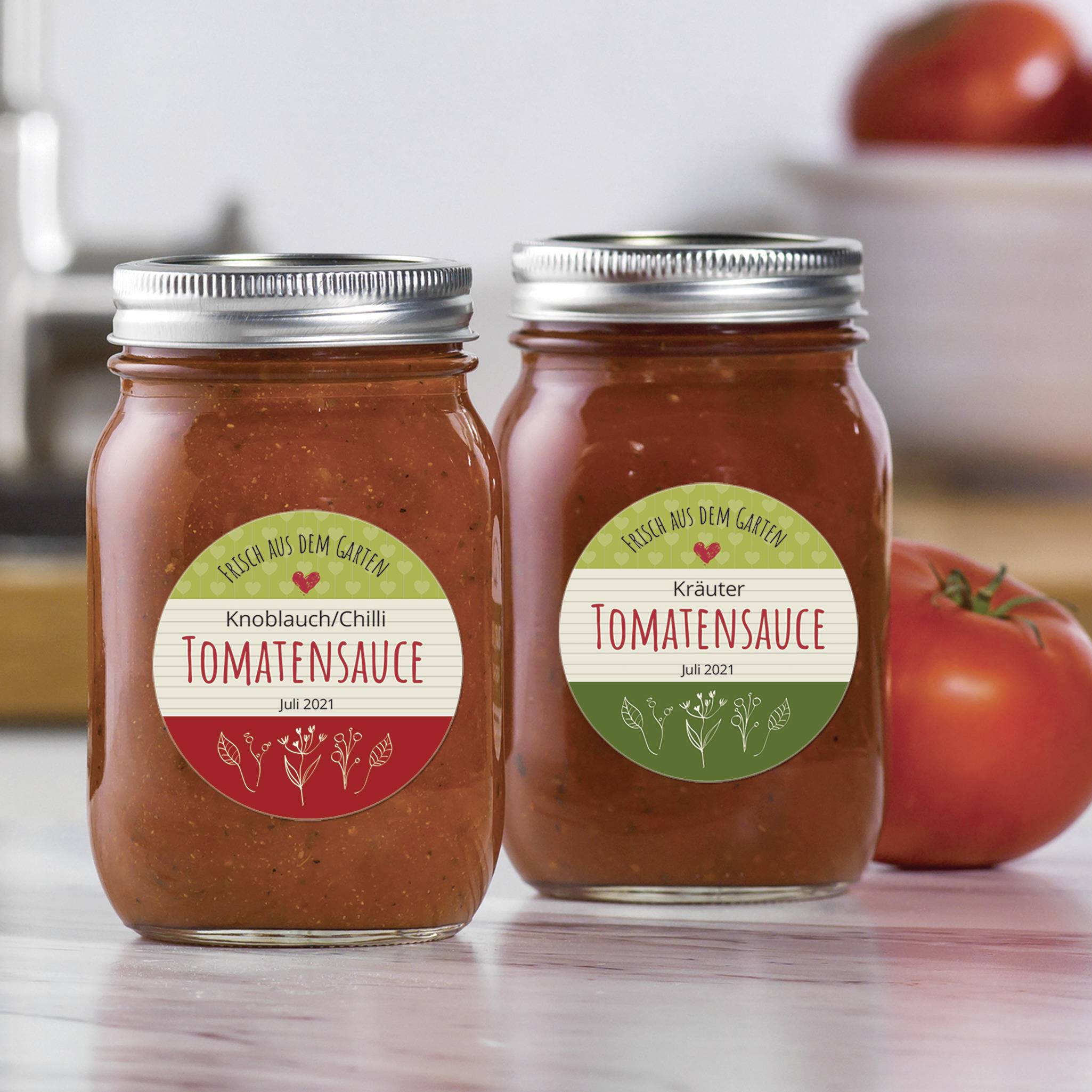 Zwei Einmachgläser mit hausgemachter Tomatensauce: links 'Knoblauch/Chilli', rechts 'Kräuter', beide mit Aufschrift 'Aus dem Garten'.