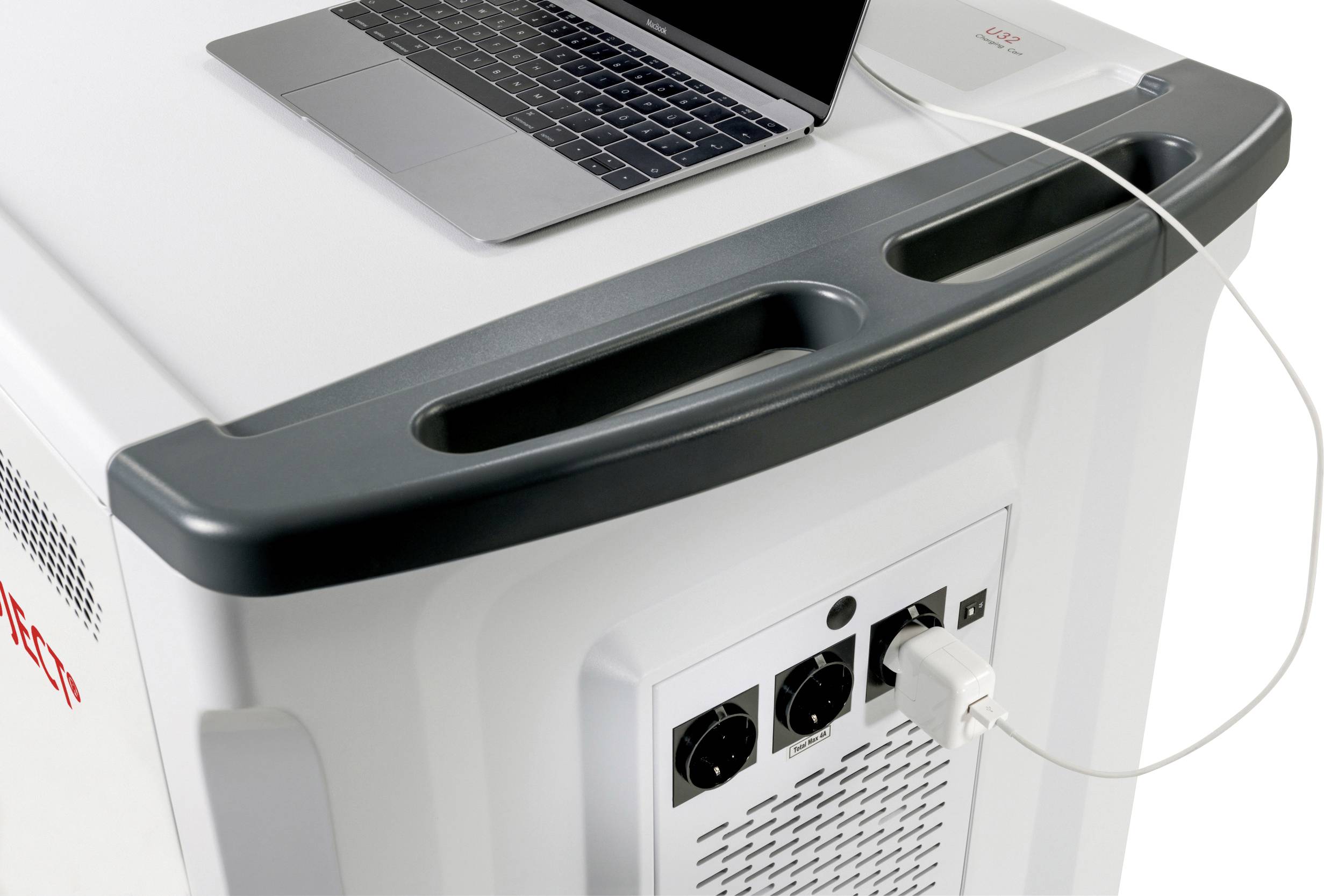 Ein Laptop ist auf einem großen elektrischen Gerät platziert, das mit zwei Drehknöpfen und mehreren Anschlüssen ausgestattet ist. Ein Kabel verbindet den Laptop mit dem Gerät.