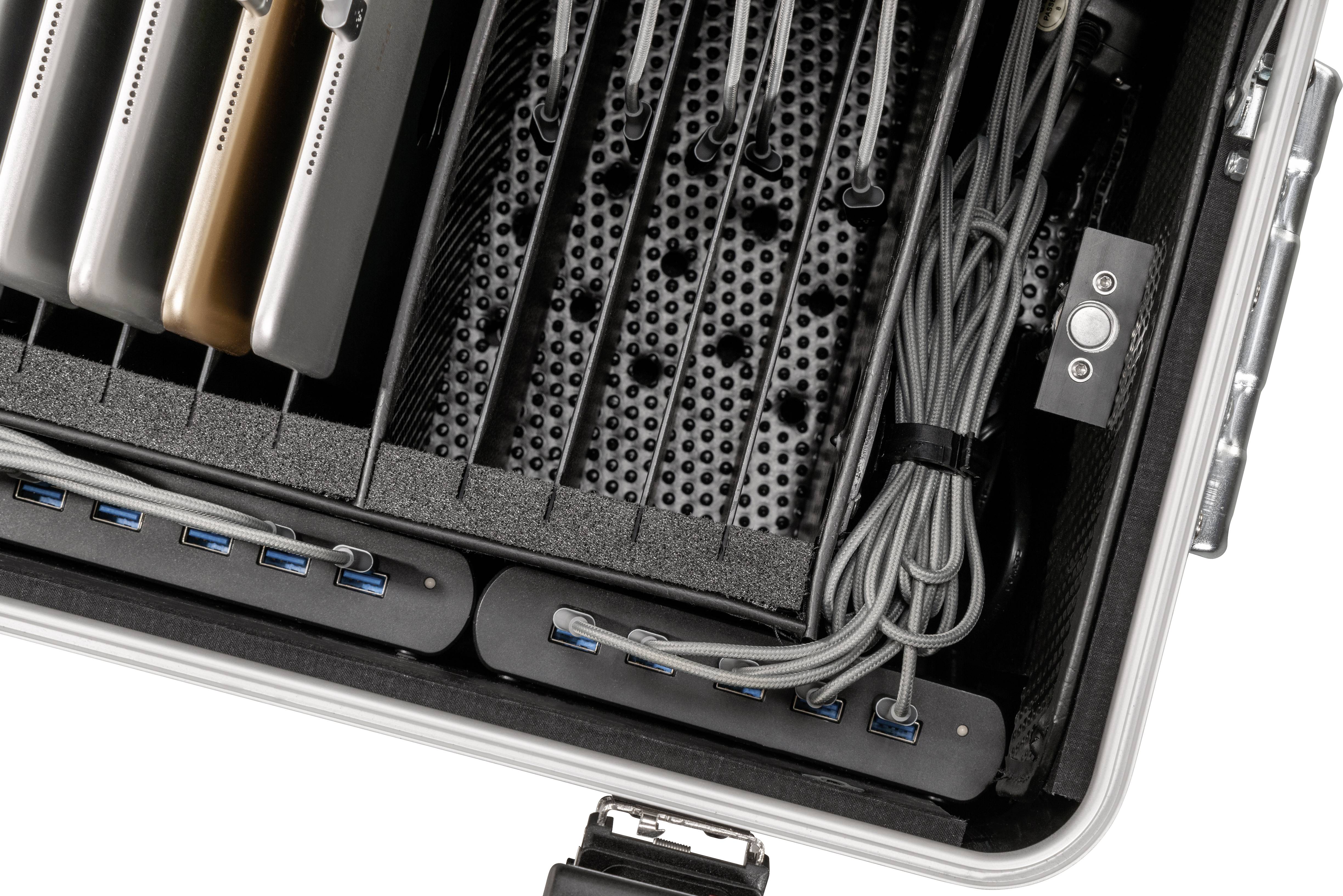 Geöffneter Koffer mit mehreren Laptops, Kabeln und USB-Anschlüssen, zum Organisieren und Aufladen von Geräten.