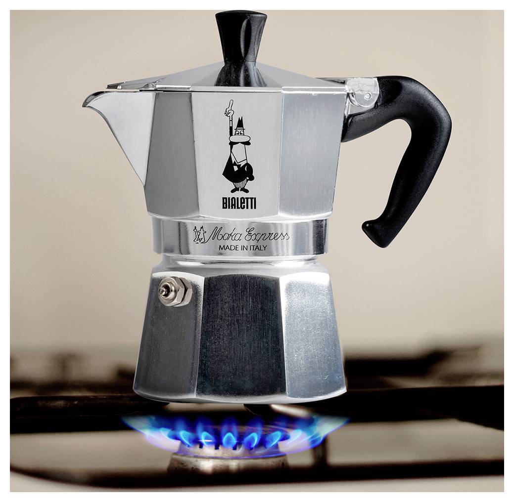 Ein silberner Espressokocher auf einem eingeschalteten Gasherd, auf dem das Markenlogo und der Schriftzug ‚Made in Italy' zu sehen sind, in einer Küchenumgebung platziert.