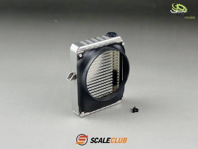 Kühlergrill-Modellbauteil von ScaleClub. Silberner Rahmen mit schwarzer Front und Lamellenstruktur. Schraube daneben auf grauem Hintergrund.
