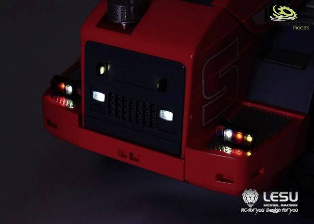 Ein rotes Modellfahrzeug mit leuchtenden Scheinwerfern und Rücklichtern auf dunklem Hintergrund, mit 'LESU' Logo rechts unten.