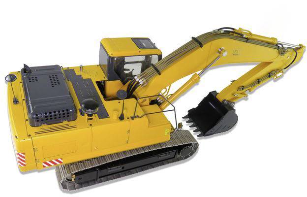 Gelber Bagger mit einem schwarzen Greifer auf Gleisketten, bereit für Erdarbeiten.