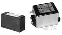Zwei elektronische Bauteile: links ein rechteckiges, schwarz verkleidetes Relais, rechts ein größeres, metallisches Filtergehäuse mit Anschlüssen.