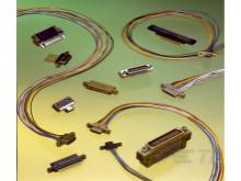 Verschiedene Computerstecker und Kabel auf gelbem Hintergrund, darunter parallele und serielle Anschlüsse.