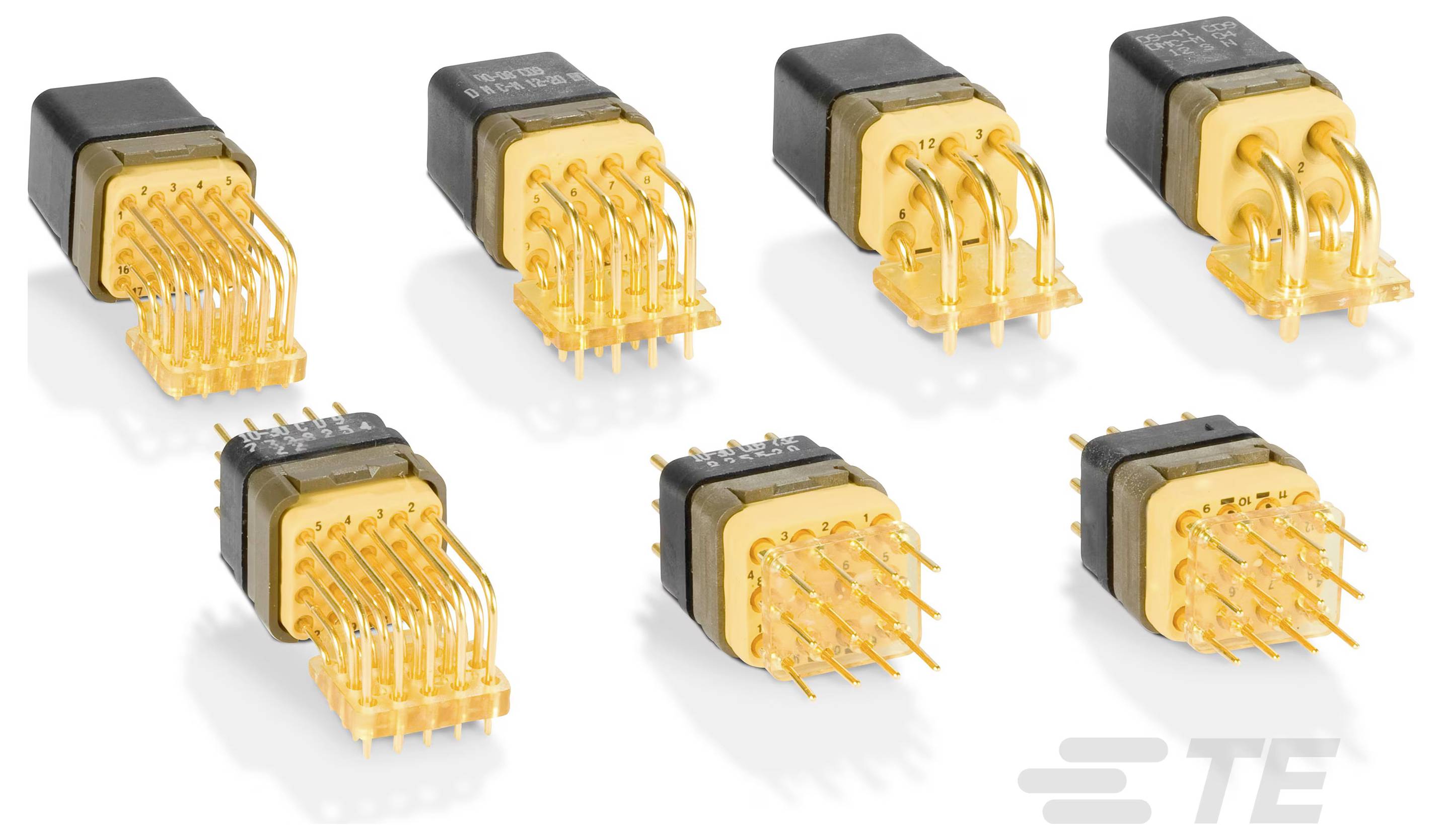 Sieben vergoldete elektrische Stecker mit mehreren Kontakten, angeordnet in zwei Reihen.