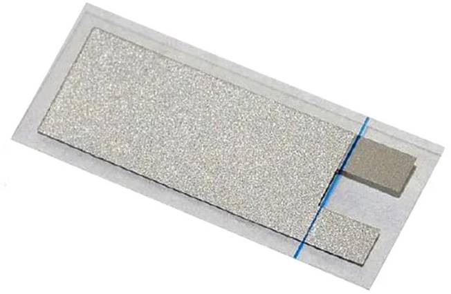 Ein Nahaufnahme eines metallischen Streifensensors auf weißem Hintergrund, das seine flache rechteckige Form mit einer blauen Linie und zwei quadratischen Kontakten zeigt.