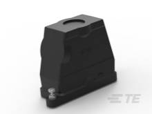 Ein schwarzes, rechteckiges technisches Bauteil mit abgerundeten Kanten, auf einem weißen Hintergrund. Links unten ist eine silberne Schraube sichtbar.