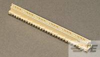 Ein goldfarbener gezackter Gegenstand mit ungefähr 20 gleichmäßig angeordneten Zähnen. Hintergrund ist unscharf und beige.