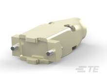 Ein beige, zylinderförmiges mechanisches Teil mit rechteckigem Flansch, zwei Befestigungsschrauben, auf hellem Hintergrund.