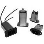 Vier verschiedene elektrische Komponenten, darunter rechteckige Gehäuse mit Steckverbindungen und Kabeln, auf hellem Hintergrund.