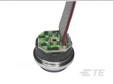 Ein elektronisches Bauteil mit Kabeln und einer runden Metallbasis. Es könnte ein Sensor oder ein kleiner Motor sein.