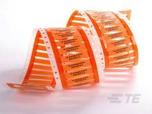 Endlosstreifen aus orangem Band mit Lochkarten, verwendet für alte Computer und Datenverarbeitung.